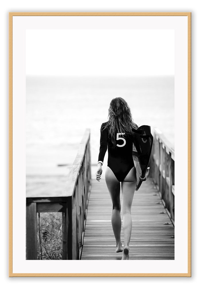 A black and white fashion wall art with fashion model Gisele Bunchen holding Chanel N5 surf board. 