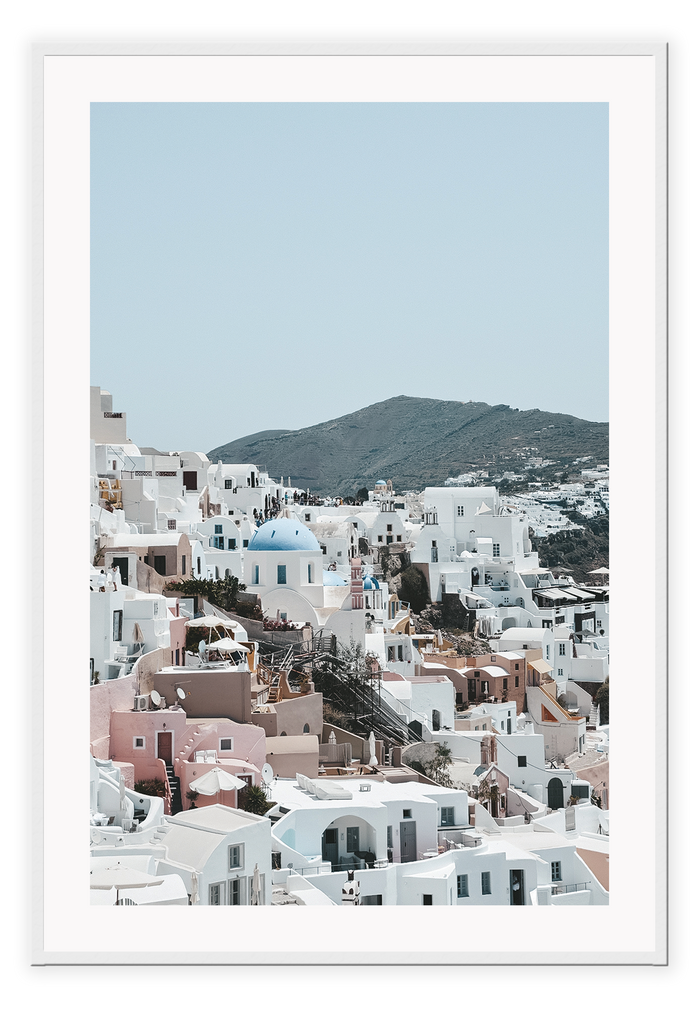 Greece, coastal architecture pastel colours blue sky mountain in background