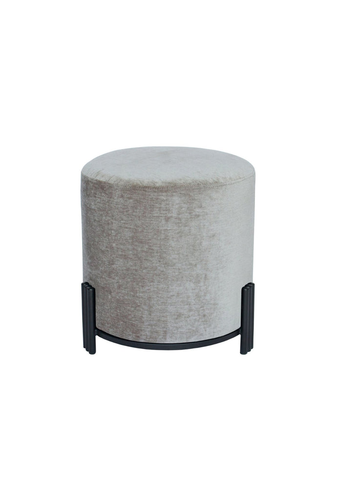 Round Ottoman upholstered in silver grey velvet with matte black metal base and three ribbed legs on white background