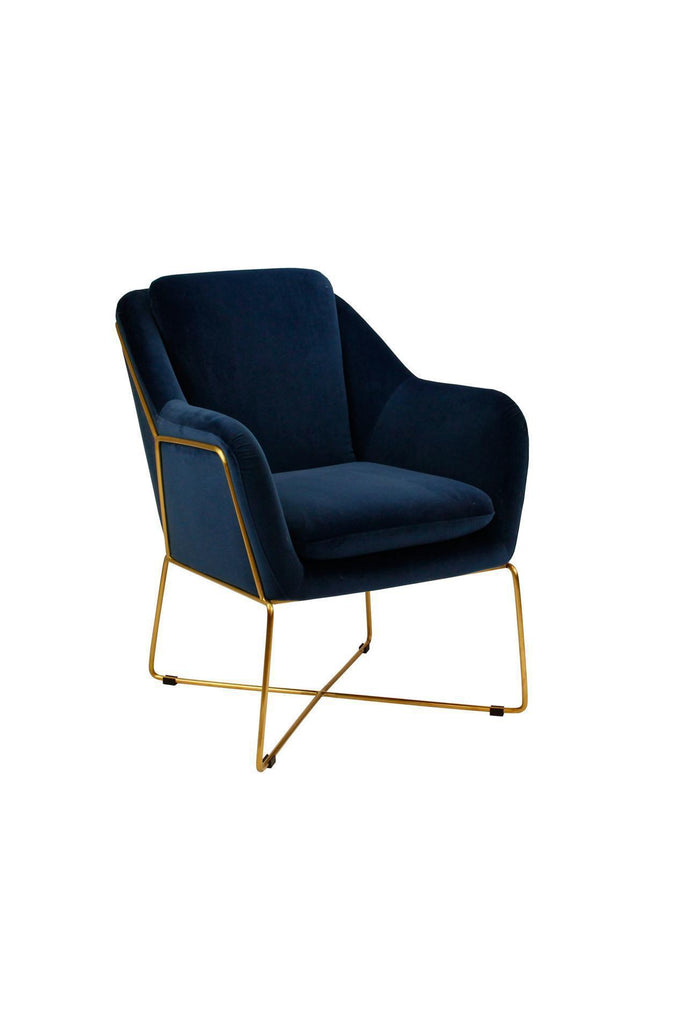 Modern armchair fully upholstered in navy blue velvet with slim gold metal legs connecting at the bottom forming a crossed base