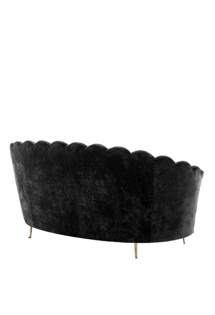 Curved Black Velvet Sofa with Stitching and Piping Detailing Creating an Oyster Shaped Back Rest and four antique gold metal legs