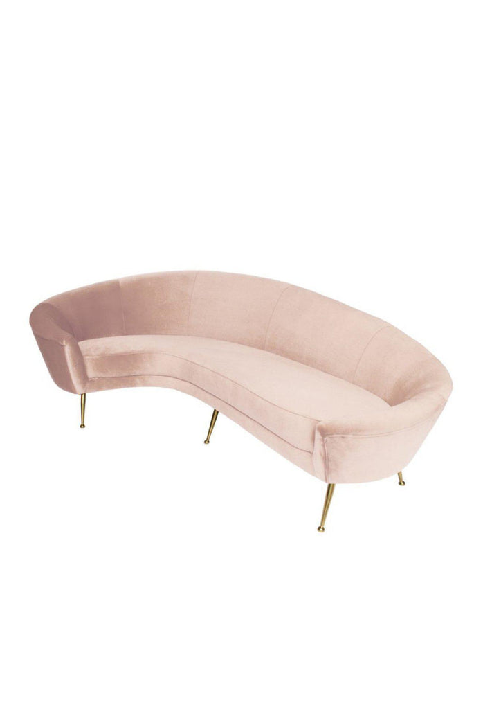 Curved blush pink velvet sofa with equally curved back rest and thin brushed gold metal legs on white background