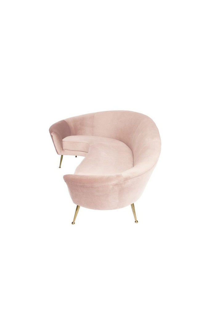 Curved blush pink velvet sofa with equally curved back rest and thin brushed gold metal legs on white background