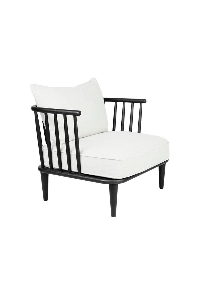 Black wooden spindle chair with white linen seat and back cushions on a white background