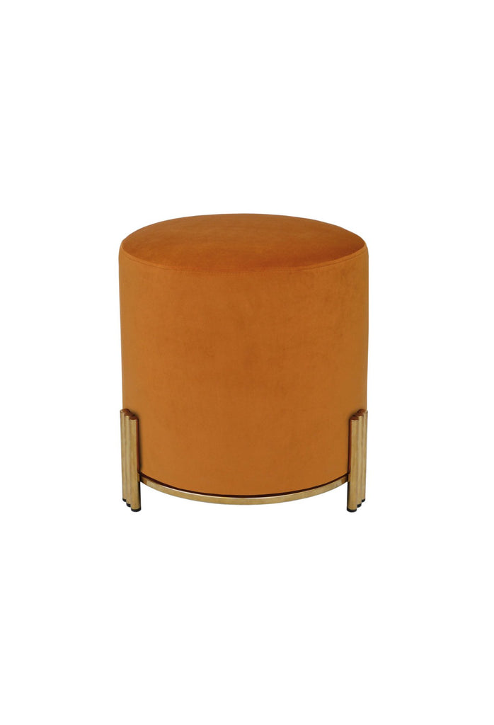 Round Ottoman upholstered in orange velvet with brushed gold metal base and three ribbed legs on white background
