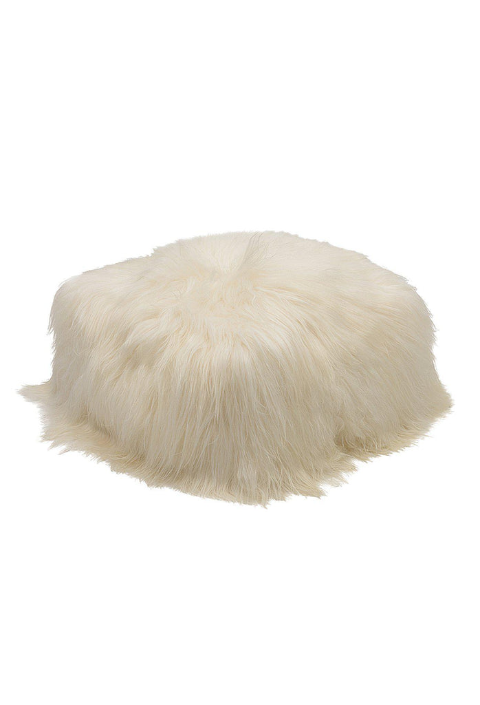 Cubic pouffe with round edges fully upholstered in natural white icelandic sheepskin on white background