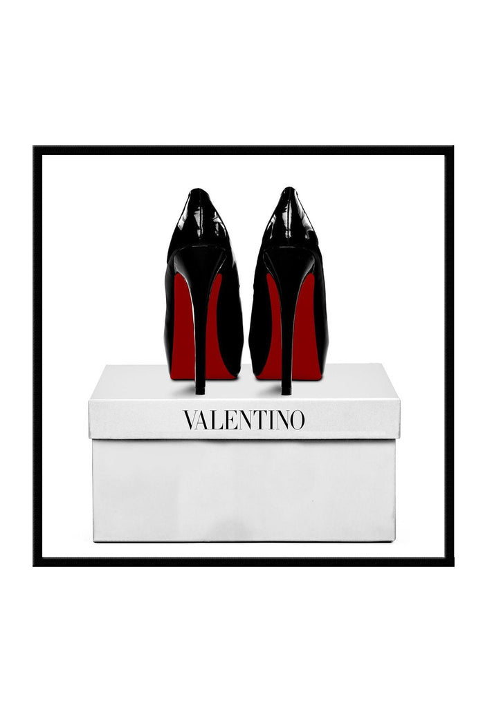Square photography of red bottom black heels on top of a white valentino box on a white background  
