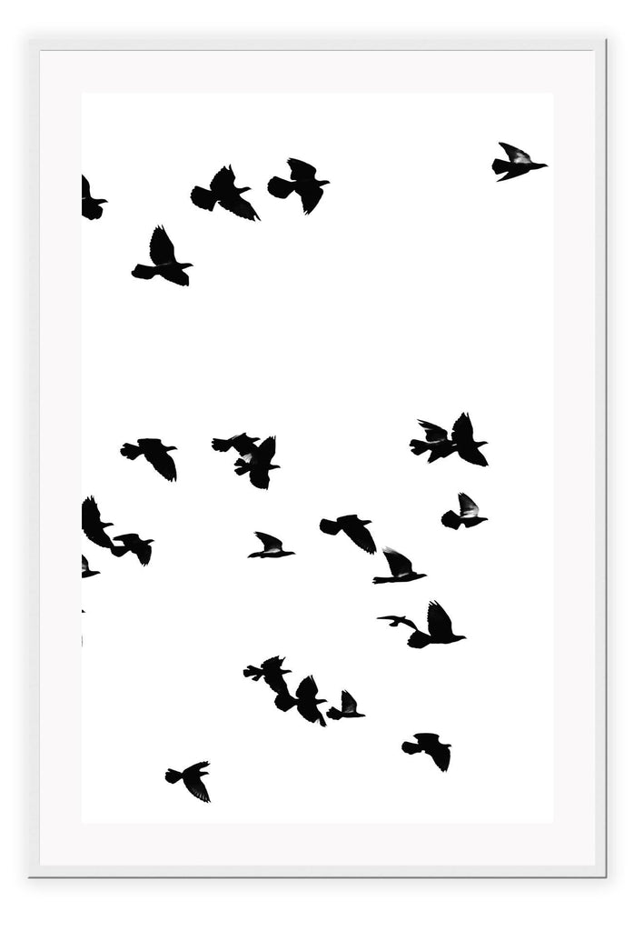 A black and white wall art with black sky birds in white sky. 